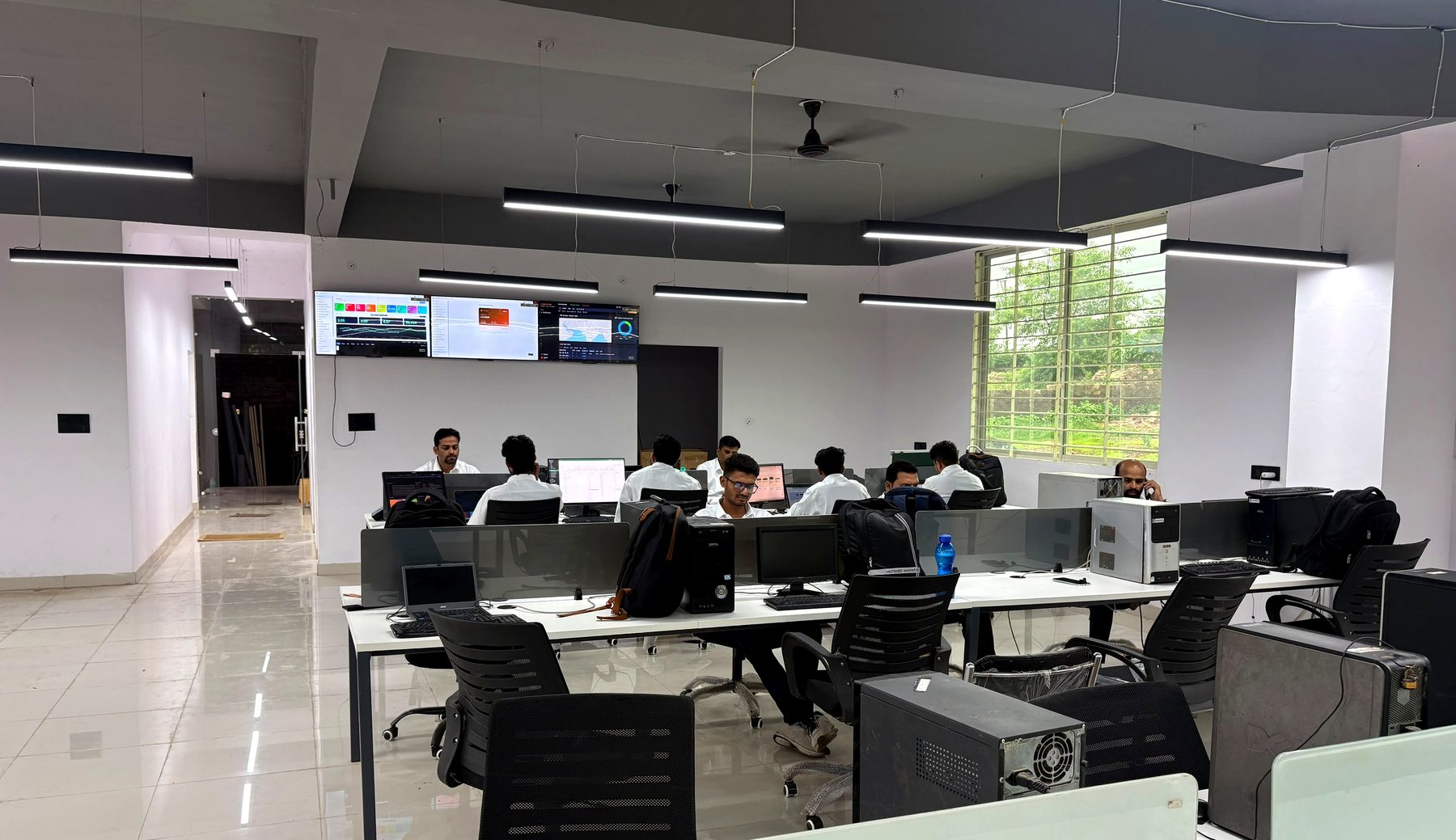 CyboWatch office floor with analysts at workstations and wall-mounted SOC dashboards